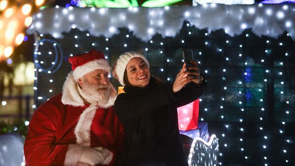 Человек в костюме Санта-Клауса фотографируется с девушкой в Италии  - Sputnik Молдова
