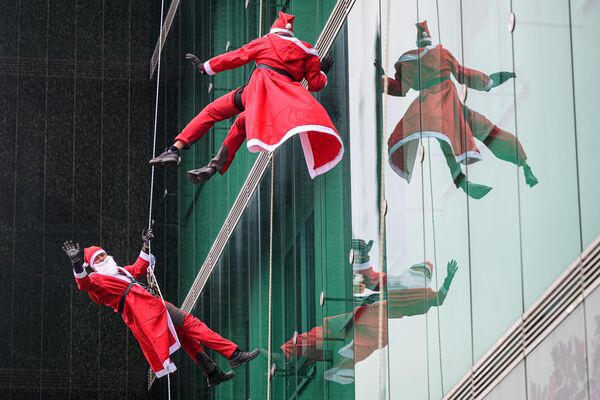 Альпинисты в костюмах Санта-Клауса поднимаются на здание детской клиники Медицинского центра Люблянского университета, Словения. - Sputnik Молдова