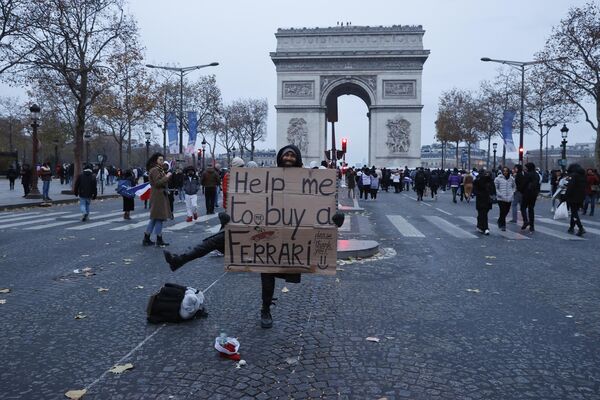 Мужчина с плакатом &quot;Помогите мне купить Ferrari&quot; на фоне Триумфальной арки в Париже. - Sputnik Молдова
