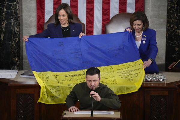 Президент Украины Владимир Зеленский вручает законодателям украинский флаг, который держат вице-президент Камала Харрис и спикер Палаты представителей Нэнси Пелоси, с автографами военных из Бахмута, выступая на совместном заседании Конгресса на Капитолийском холме в Вашингтоне. - Sputnik Молдова