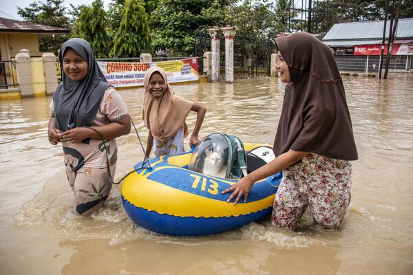 Люди спасают кошку в затопленном районе в Матангкули, Индонезия. - Sputnik Молдова