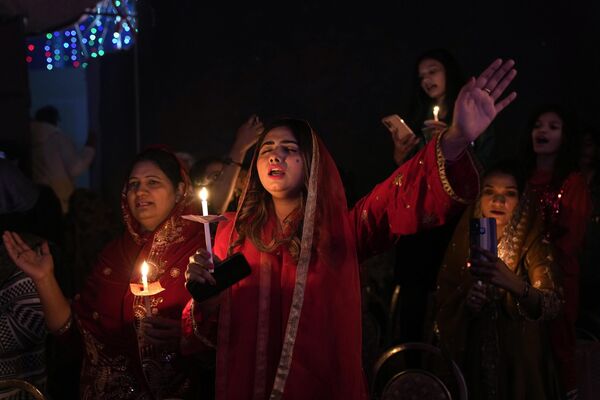 Пакистанские христиане держат свечи во время службы по случаю празднования Рождества в Лахоре, Пакистан. - Sputnik Молдова