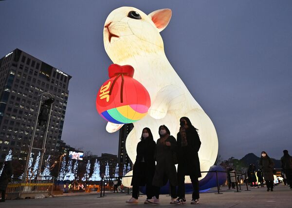 Люди проходят мимо освещенного фонаря в честь наступающего Года Кролика в Сеуле, Южная Корея. - Sputnik Молдова