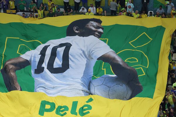 Un mare drapel al legendei Braziliei Pele este dezvăluit în mulțime înaintea meciului de fotbal din Grupa G pentru Cupa Mondială Qatar 2022 dintre Camerun și Brazilia, pe stadionul Lusail din Lusail, la nord de Doha, pe 2 decembrie 2022. - Sputnik Moldova-România