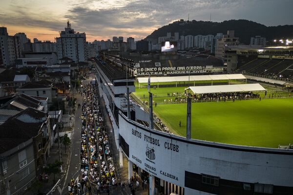 Oamenii stau la coadă pentru a intra pe stadionul Vila Belmiro din Santos, unde se află sicriul cu trupul neînsuflețit al fotbalistului brazilian Pele, 2 ianuarie 2023. - Sputnik Moldova