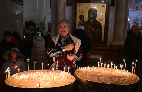 Верующий на православной рождественской службе в кафедральном соборе Самеба в Тбилиси. - Sputnik Молдова