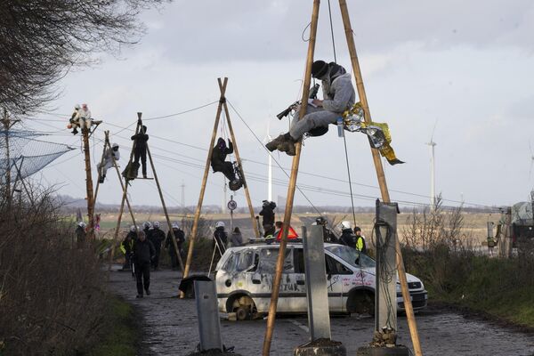 Климатические активисты сидят в так называемых трипо и блокируют дорогу в деревне Лютцерат недалеко от Эркеленца, Германия, среда, 11 января 2023 года. Они протестуют против открытия угольной шахты.  - Sputnik Молдова
