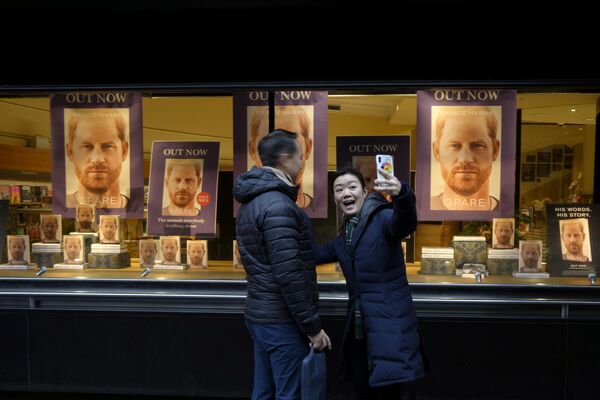 Пара фотографируется перед витриной книжного магазина в Лондоне, где размещена новая книга мемуаров принца Гарри &quot;Запасной&quot;, вторник, 10 января 2023 года. - Sputnik Молдова