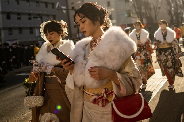 Молодые женщины носят кимоно, чтобы отметить &quot;День совершеннолетия&quot; в честь людей, которым в этом году исполняется 20 лет, в Йокогаме, префектура Канагава, 9 января 2023 года (фото Филиппа Фонга / AFP) - Sputnik Молдова