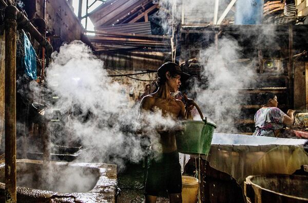 Рабочий готовит соевые бобы на традиционной фабрике тофу в Богоре, 7 января 2023 года (фото ADITYA AJI / AFP). - Sputnik Молдова