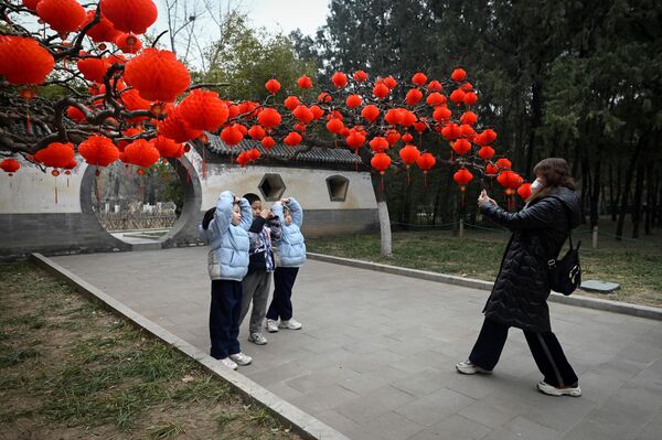 Красные фонари на дереве в парке в Пекине и любители ярких фотографий. - Sputnik Молдова