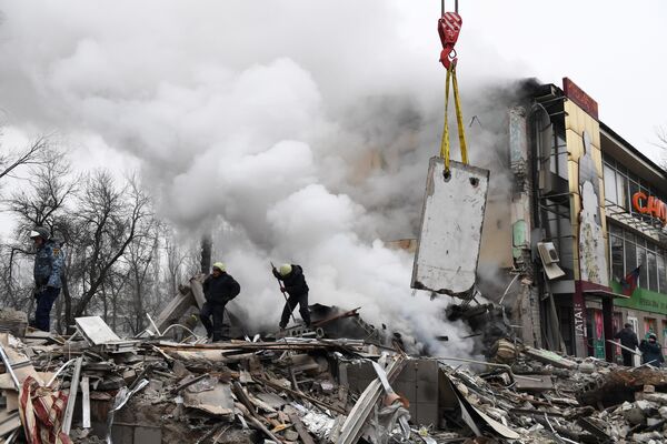 Спасатели на месте разрушенного в результате обстрела со стороны ВСУ торгового центра в Донецке, Россия - Sputnik Молдова