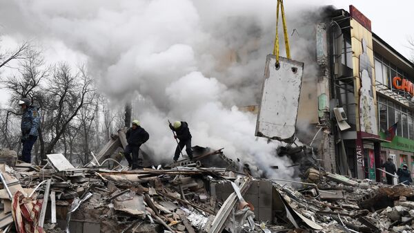 Спасатели на месте разрушенного в результате обстрела со стороны ВСУ торгового центра в Донецке, Россия - Sputnik Moldova
