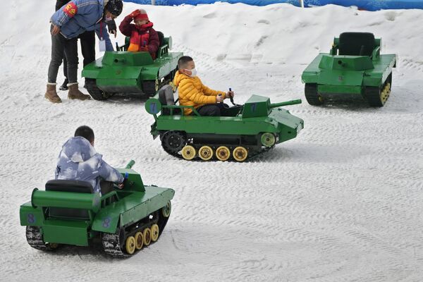 Дети катаются на игрушечных танках по снегу в общественном парке Пекина. - Sputnik Молдова