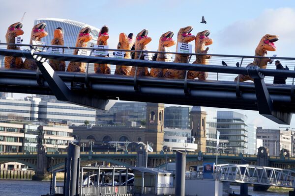 Сторонники PETA (Люди за этичное обращение с животными), одетые в костюмы динозавров, проходят по мосту Миллениум в Лондоне. - Sputnik Молдова