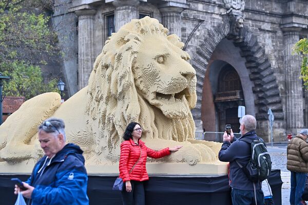 Туристы позируют перед гигантской статуей льва из конструктора Lego, точной копией одной из львиных статуй старейшего в Венгрии Цепного моста в Будапеште. - Sputnik Молдова