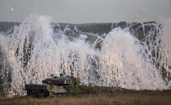 Un tanc de luptă Leopard 2 aruncă grenade de ceață în timpul unui exercițiu de antrenament la terenul militar din Ostenholz, nordul Germaniei, pe 17 octombrie 2022. - Sputnik Moldova
