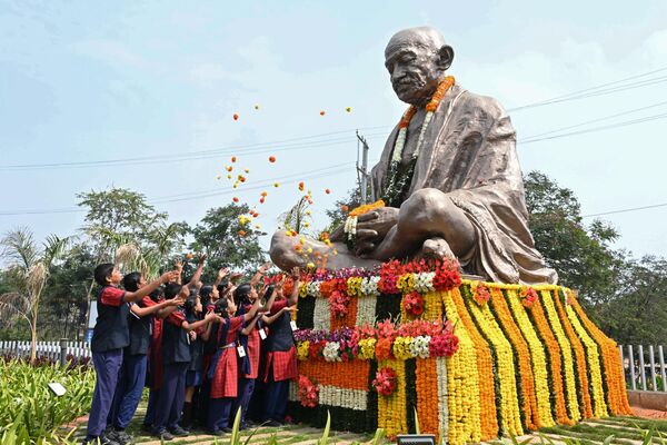 Школьники бросают цветы к статуе Махатмы Ганди в годовщину его смерти в Хайдарабаде, Индия. - Sputnik Молдова