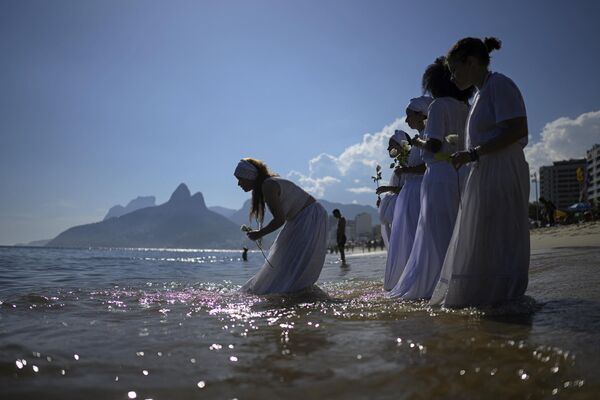 Верующие принимают участие в традиционной церемонии Иеманьи, богини моря синкретической афро-бразильской религии Умбанда, на пляже в Рио-де-Жанейро, Бразилия. - Sputnik Молдова