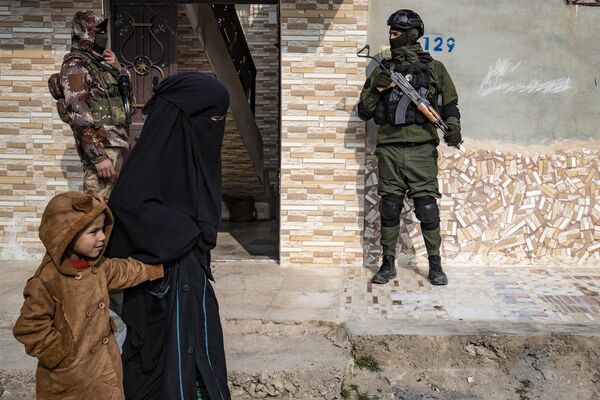 Сирийские курдские силы безопасности &quot;Асаеш&quot; на страже возле дома во время рейда против подозреваемых боевиков группировки &quot;Исламское государство&quot;* в Ракке. - Sputnik Молдова