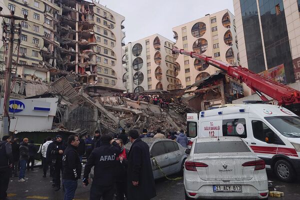 Salvatorii și echipele medicale încearcă să ajungă la rezidenții blocați într-o clădire prăbușită în urma unui cutremur din Diyarbakir, sud-estul Turciei, luni dimineața, 6 februarie 2023 - Sputnik Moldova-România
