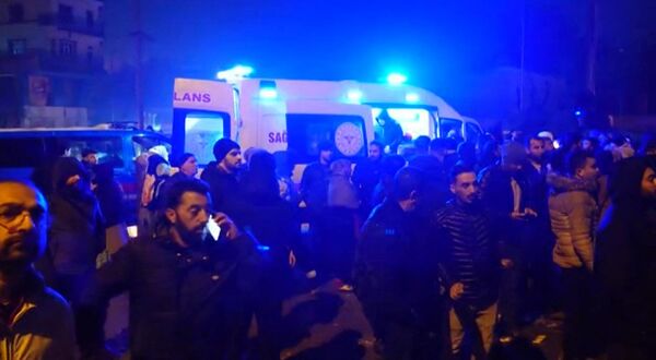 În această captură video de la AFP TV, realizată pe 6 februarie 2023, oameni stau lângă o ambulanță în timp ce salvatorii caută victimele în urma cutremurului cu magnitudinea de 7,8 care a lovit Diyarbakir, în sud-estul Turciei - Sputnik Moldova-România