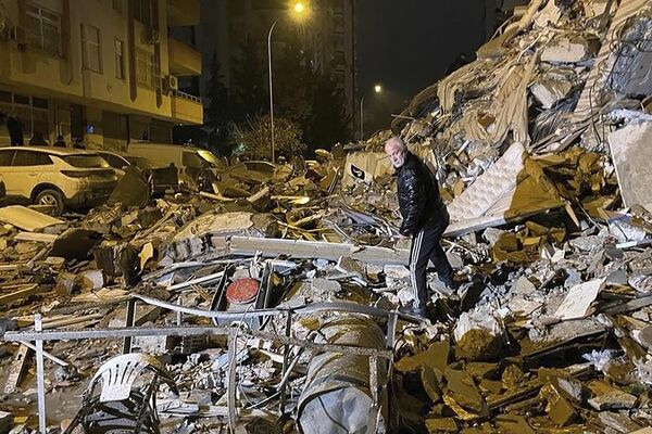 Un bărbat caută posibile victime care ar putea să existe  printre clădirile prăbușite ca urmare a cutremurului care s-a produs în Diyarbakir din sudul Turciei, 6 februarie 2023. - Sputnik Moldova-România