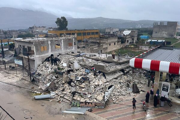 Oamenii caută printre epavele unei clădiri prăbușite în orașul Azmarin, în provincia Idlib, nordul Siriei, 6 februarie 2023. - Sputnik Moldova-România