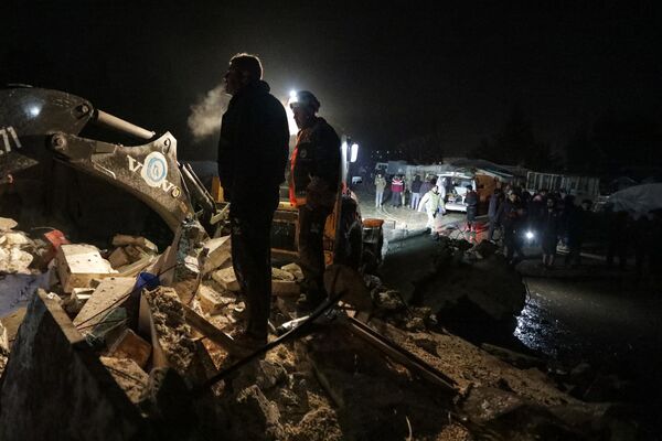 Salvatori sirieni și locuitori ai  orașului Azaz, în nordul provinciei Alep, sunt adunați lângă o clădire care s-a prăbușit în urma cutremurului  - Sputnik Moldova-România