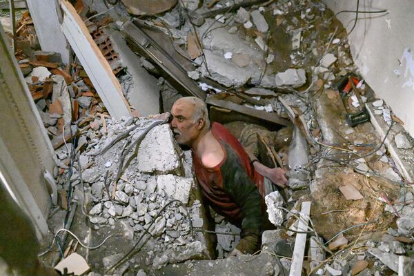 Мужчина, застрявший в обломках, реагирует, когда обломки убирают для его спасения в Хатае 7 февраля 2023 года, через день после землетрясения силой 7,7 балла на юго-востоке страны. Спасатели в Турции и Сирии, невзирая на холодную погоду, подземные толчки и рушащиеся здания, выкапывали выживших, погребенных в результате землетрясения, унесшего жизни более 5000 человек. ВОЗ предупредила во вторник, что до 23 миллионов человек могут пострадать от сильного землетрясения, в результате которого погибли тысячи людей в Турции и Сирии, обещая долгосрочную помощь (фото БУЛЕНТ КИЛИЧ/AFP). - Sputnik Молдова