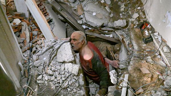 Un bărbat încearcă să se salveze după ce a fost prins sub ruinele clădirii în care se afla în timp cutremurelor care a zguduit Turcia și Siria - Sputnik Moldova