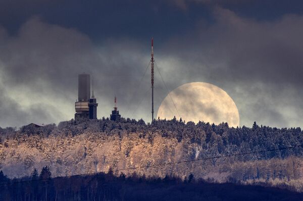 Луна садится за вершину горы Фельдберг недалеко от Франкфурта, Германия, рано утром в понедельник, 6 февраля 2023 года (AP Photo/Michael Probst). - Sputnik Молдова