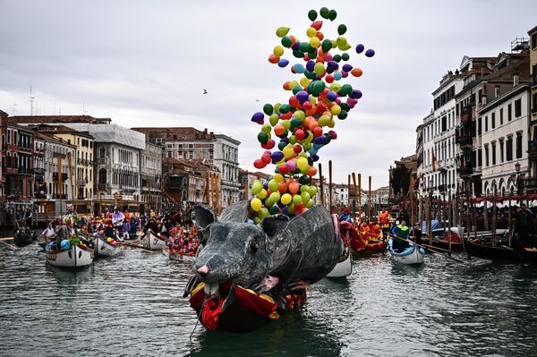 Вид на воздушные шары, взлетающие с &quot;лодки-крысы&quot; (barca della pantegana), когда гуляки собираются на Гранд-канале на водный парад Координации венецианских гребных ассоциаций во время Венецианского карнавала 5 февраля 2023 года (фото Марко БЕРТОРЕЛЛО/AFP). - Sputnik Молдова