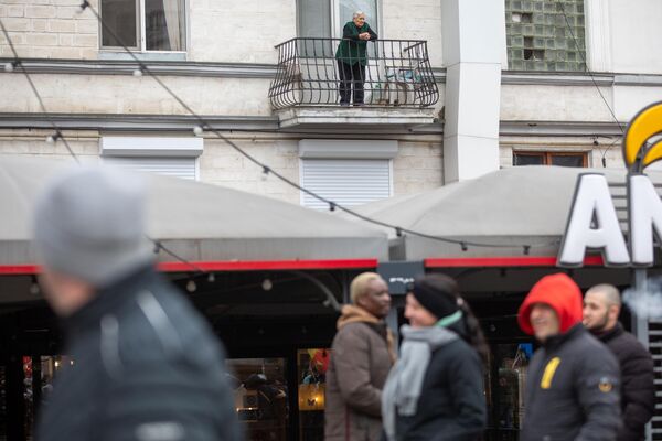 Protestul Mișcării Pentru Popor 28.02.2023. Un locuitor al Chișinăului privește de la balcon coloana de manifestanți. - Sputnik Moldova