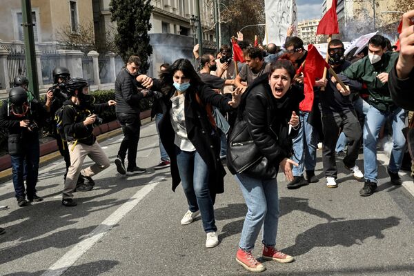 Протестующие кричат ​​в сторону полицейских, распыляющих газ, во время массовой демонстрации в Афинах 5 марта 2023 года после железнодорожной аварии, которая произошла поздно вечером 28 февраля и унесла десятки человеческих жизней.  - Sputnik Молдова