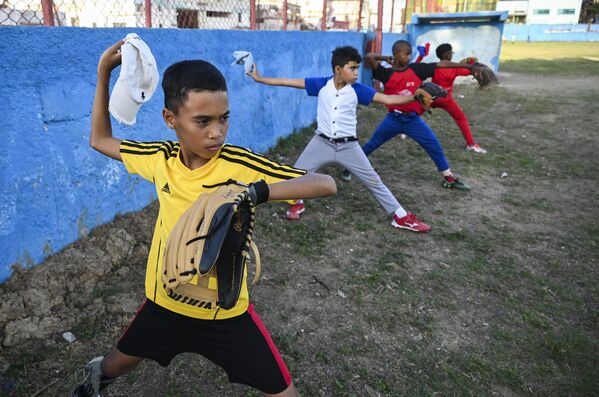 Дети принимают участие в тренировке по бейсболу  в Гаване, 6 марта 2023 г. - World Baseball Classic 2023 стартовал 7 марта 2023 г. Впервые игрокам высшей и низшей лиги, сбежавшим с Кубы, разрешено играть за команду на международных соревнованиях. Фото: YAMIL LAGE/AFP. - Sputnik Молдова