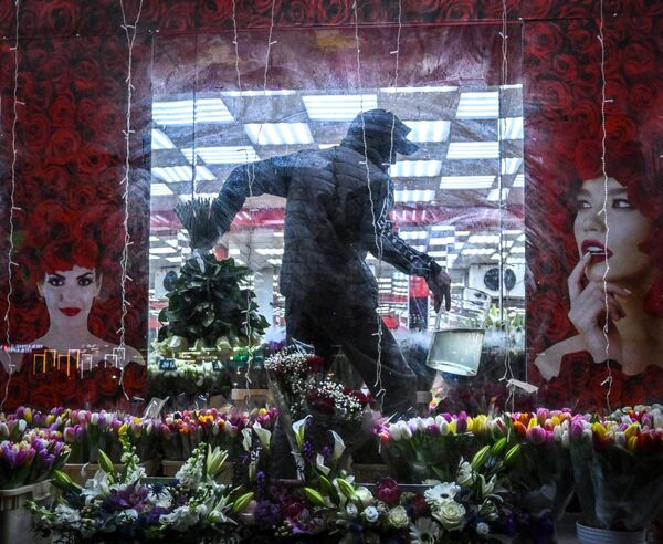 Флорист несет букет цветов в цветочном магазине в Москве 6 марта 2023 года, за два дня до Международного женского дня (фото Юрия КАДОБНОВА/AFP). - Sputnik Молдова