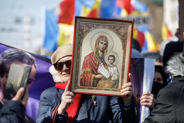 Участница протеста &quot;Движения за народ&quot; в Кишиневе держит в руках икону Богородицы. - Sputnik Молдова