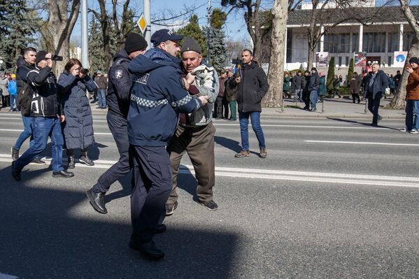 Сотрудники полиции проводят задержание одного из протестующих. - Sputnik Молдова