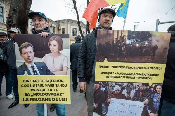 Участники антиправительственного протеста в Молдове держат в руках плакаты против милитаризации республики. - Sputnik Молдова