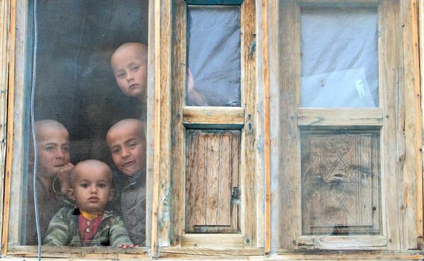 Афганские мальчики смотрят из окна своего дома в районе Яфтал-Суфла провинции Бадахшан, 12 марта 2023 года. - Sputnik Молдова