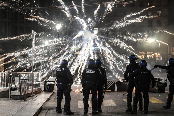 Полицейские смотрят на фейерверк, запущенный протестующими против пенсионной реформы в Леоне. - Sputnik Молдова