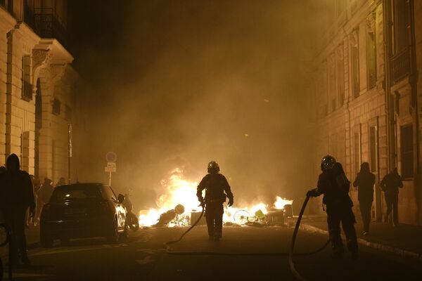 Пожарные тушат огонь возле площади Согласия в Париже после демонстрации. - Sputnik Молдова