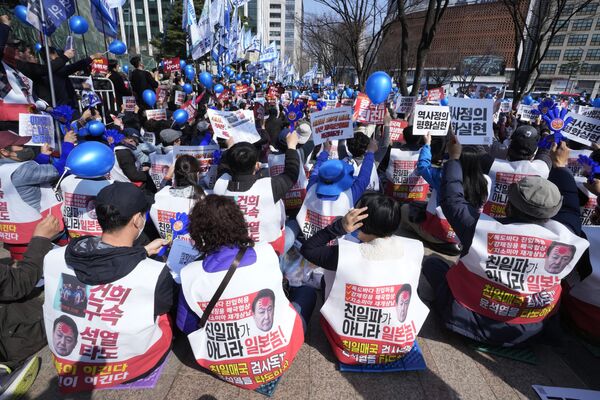 Protestatarii purtând veste cu imaginile președintelui sud-coreean Yoon Suk Yeol participă la un miting la Seul în care au denunțat summit-ul caare a avut loc dintre Coreea de Sud și Japonia în timpul unei vizite întreprinse de premierul japonez în capitala Coreeii de Sud. Seul, 18 martie 2023 - Sputnik Moldova-România