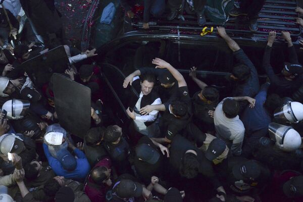 Сотрудники службы безопасности расчищают дорогу для экс-премьера Имрана Хана, прибывшего в суд в Лахоре, Пакистан. - Sputnik Молдова