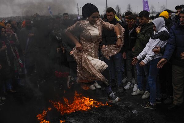 Женщина прыгает через костер во время празднования Навруза в Стамбуле. - Sputnik Молдова