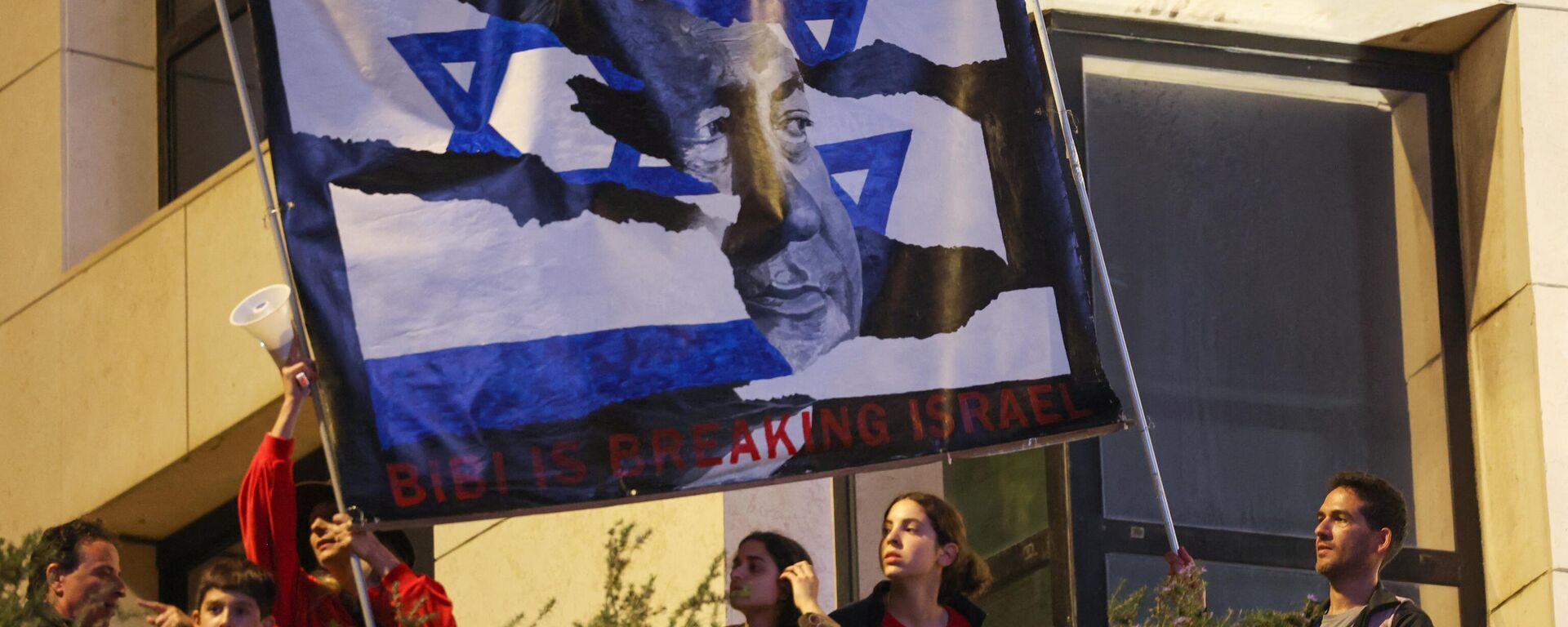 Израильские протестующие поднимают транспарант с изображением премьер-министра Биньямина Нетаньяху во время митинга против законопроекта о пересмотре судебной системы в Тель-Авиве, 25 марта 2023 года. - Sputnik Молдова, 1920, 27.03.2023