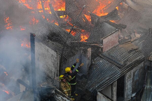 Пожарные борются с огнем в жилом районе Манилы, Филиппины. - Sputnik Молдова