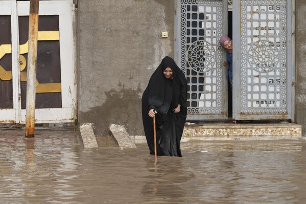 Женщина на затопленной улице в городе Наджаф, Ирак. - Sputnik Молдова