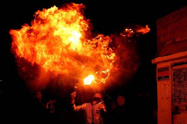 Огненное шоу во время священного для мусульман месяца Рамадан в южном ливанском городе Сидон 31 марта 2023 года. - Sputnik Молдова